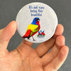 Painted bunting magnet held in hand to show 2.25-inch size and glossy finish
