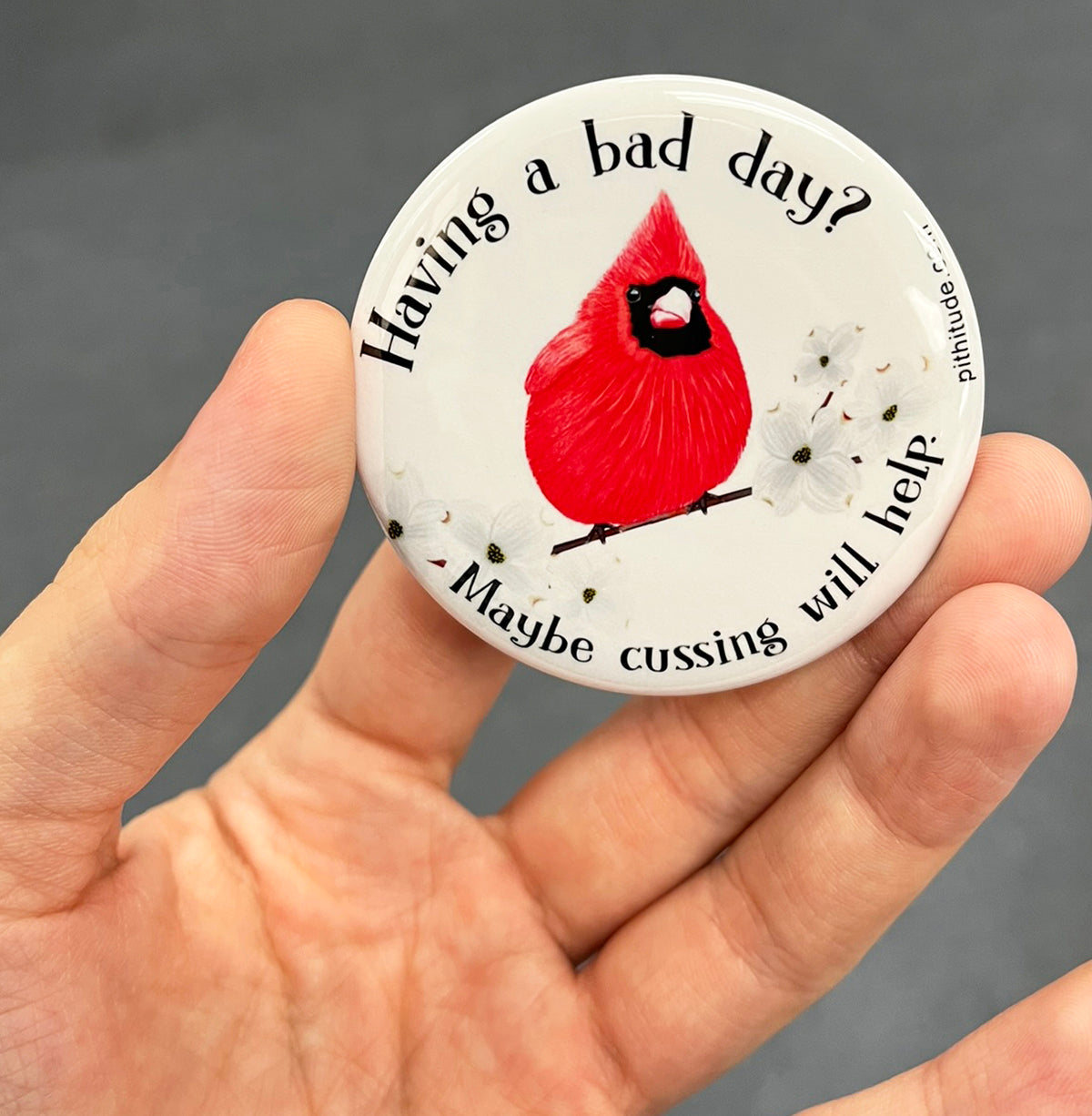 Funny cardinal magnet held in hand to show 2.25-inch size and glossy finish