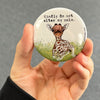 Calm giraffe magnet held in hand to show 2.25-inch size and glossy finish