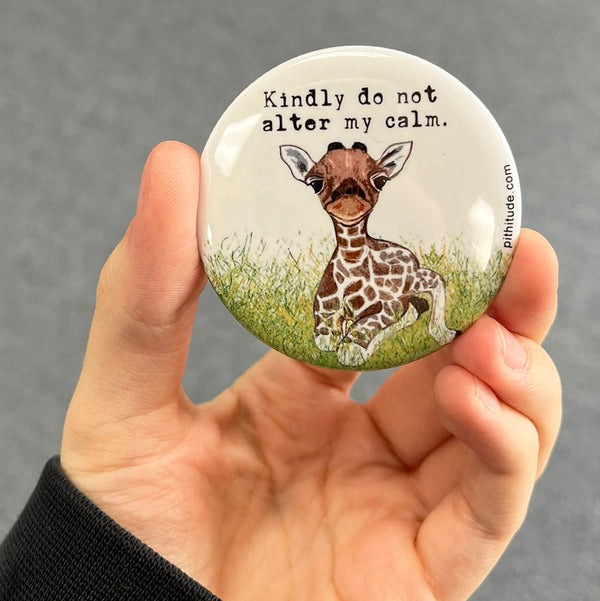 Calm giraffe magnet held in hand to show 2.25-inch size and glossy finish