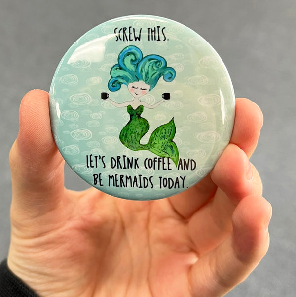 Funny mermaid magnet held in hand to show 2.25-inch size and glossy finish