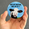 Funny cow magnet held in hand to show 2.25-inch size and glossy finish