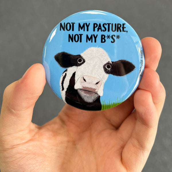 Funny cow magnet held in hand to show 2.25-inch size and glossy finish