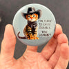 Funny cowboy kitten magnet held in hand to show 2.25-inch size and glossy finish