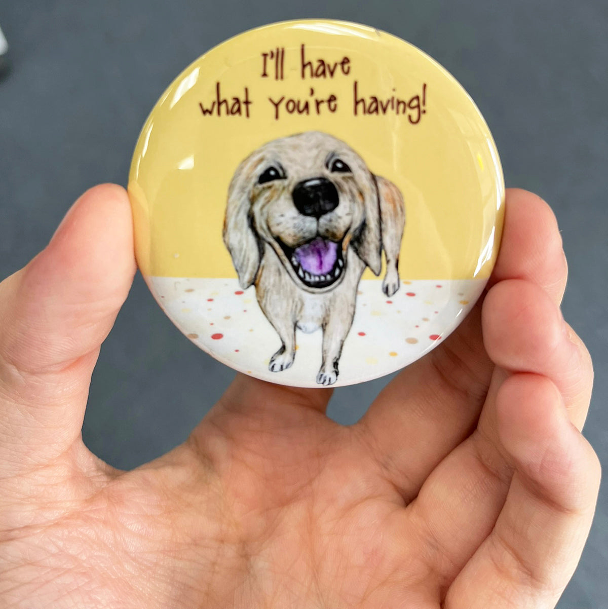 Funny Golden Retriever magnet held in hand to show 2.25-inch size and glossy finish