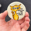 Funny cat magnet held in hand to show 2.25-inch size and glossy finish