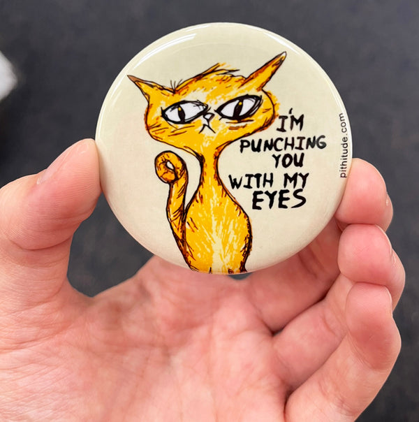 Funny cat magnet held in hand to show 2.25-inch size and glossy finish