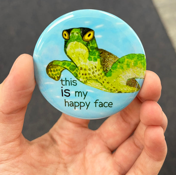 Happy sea turtle magnet held in hand to show 2.25-inch size and glossy finish