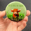 Highland cow magnet resting in an open palm with glossy finish visible