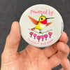 Inspirational hummingbird magnet held in hand to show 2.25-inch size and glossy finish