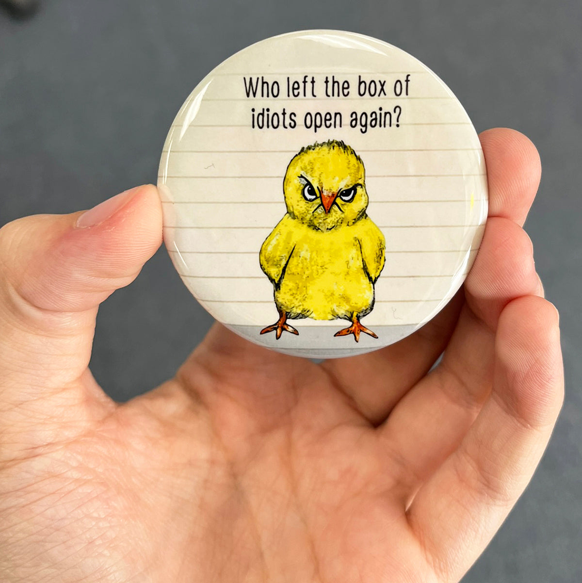 Funny chicken magnet held in hand to show 2.25-inch size and glossy finish