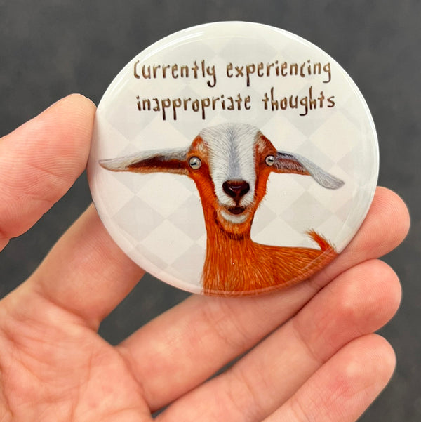 Funny goat magnet held in hand to show 2.25-inch size and glossy finish