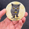 Funny office cat magnet held in hand to show 2.25-inch size and glossy finish