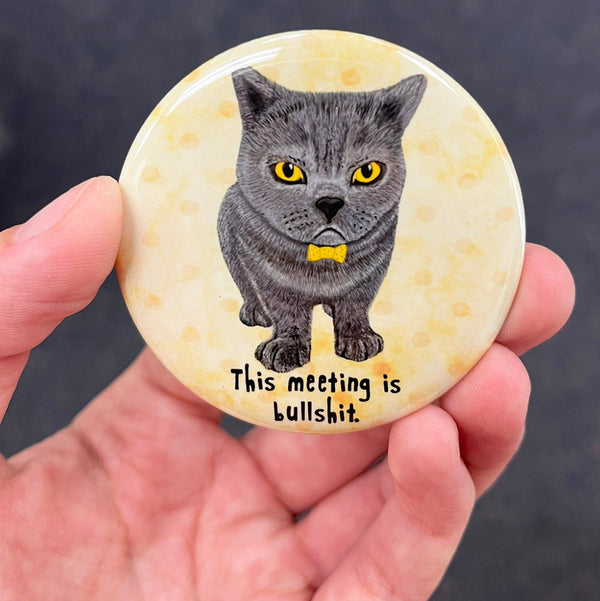 Funny office cat magnet held in hand to show 2.25-inch size and glossy finish