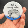 Funny hedgehog magnet held in hand to show 2.25-inch size and glossy finish