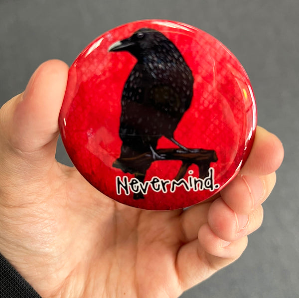Funny raven magnet held in hand to show 2.25-inch size and glossy finish