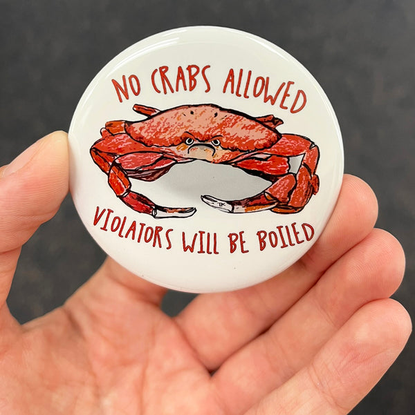 Funny crab magnet held in hand to show 2.25-inch size and glossy finish