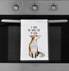 Tea towel with fox illustration and text hanging on an oven door
