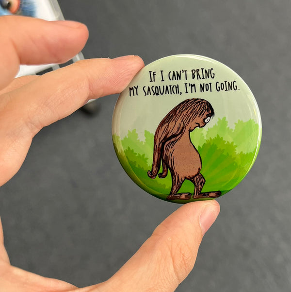 Funny Sasquatch magnet held in hand to show 2.25-inch size and glossy finish