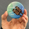 Romantic sea otter magnet resting in an open palm with glossy finish visible