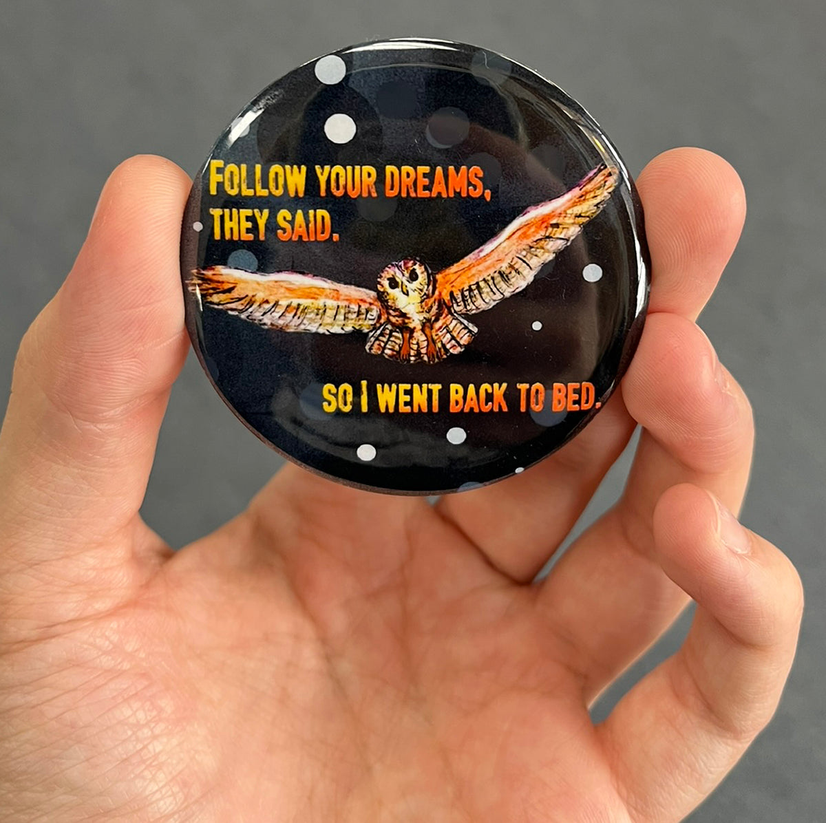 Funny sleepy owl magnet held in hand to show 2.25-inch size and glossy finish