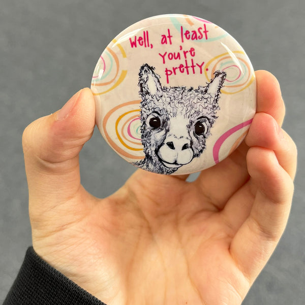 Funny alpaca magnet held in hand to show 2.25-inch size and glossy finish