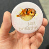 Inspirational pufferfish magnet held in hand to show 2.25-inch size and glossy finish