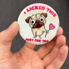 Funny pug magnet held in hand to show 2.25-inch size and glossy finish