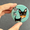 Funny Chihuahua magnet held in hand to show 2.25-inch size and glossy finish