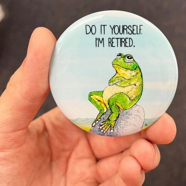 Funny retirement magnet held in hand to show 2.25-inch size and glossy finish