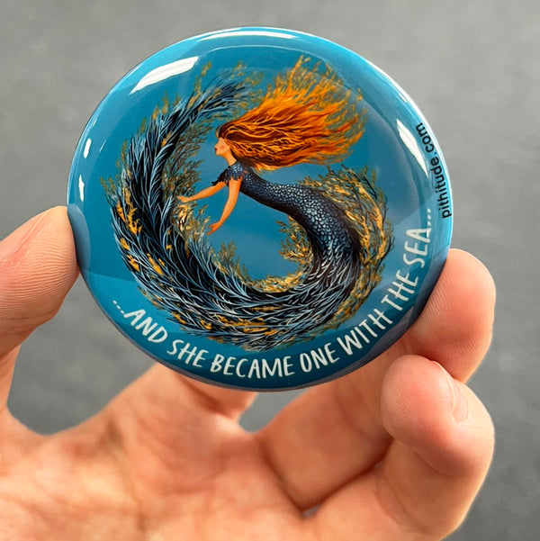 Whimsical mermaid magnet held in hand to show 2.25-inch size and glossy finish