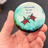 Romantic sea turtle magnet held in hand to show 2.25-inch size and glossy finish
