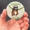 Funny sloth magnet held in hand to show 2.25-inch size and glossy finish
