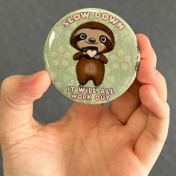 Inspirational sloth magnet held in hand to show 2.25-inch size and glossy finish
