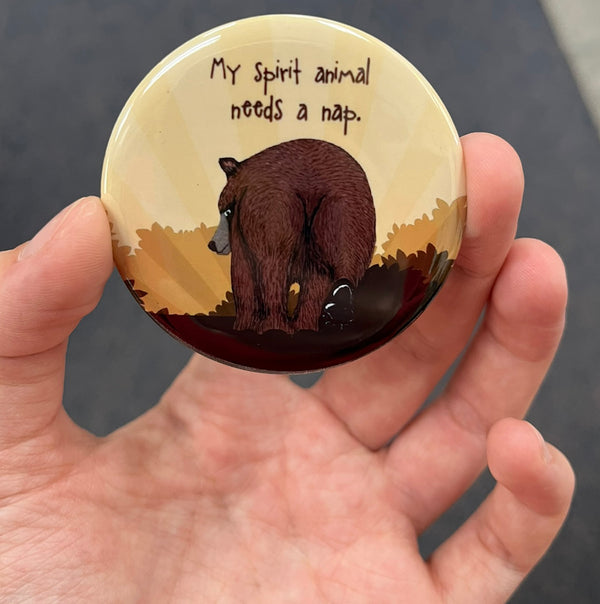 Funny bear magnet held in hand to show 2.25-inch size and glossy finish