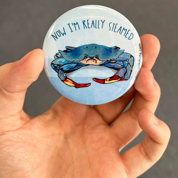 Funny blue crab magnet held in hand to show 2.25-inch size and glossy finish
