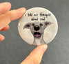 Funny dog magnet held in hand to show 2.25-inch size and glossy finish