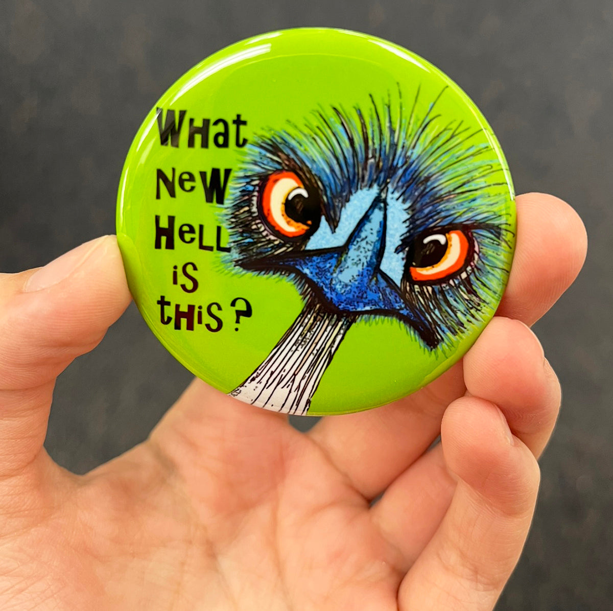 Funny emu magnet held in hand to show 2.25-inch size and glossy finish