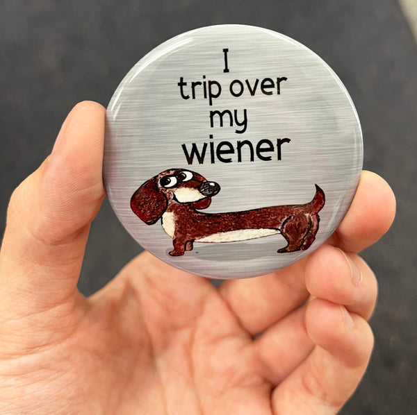 Funny dachshund magnet held in hand to show 2.25-inch size and glossy finish